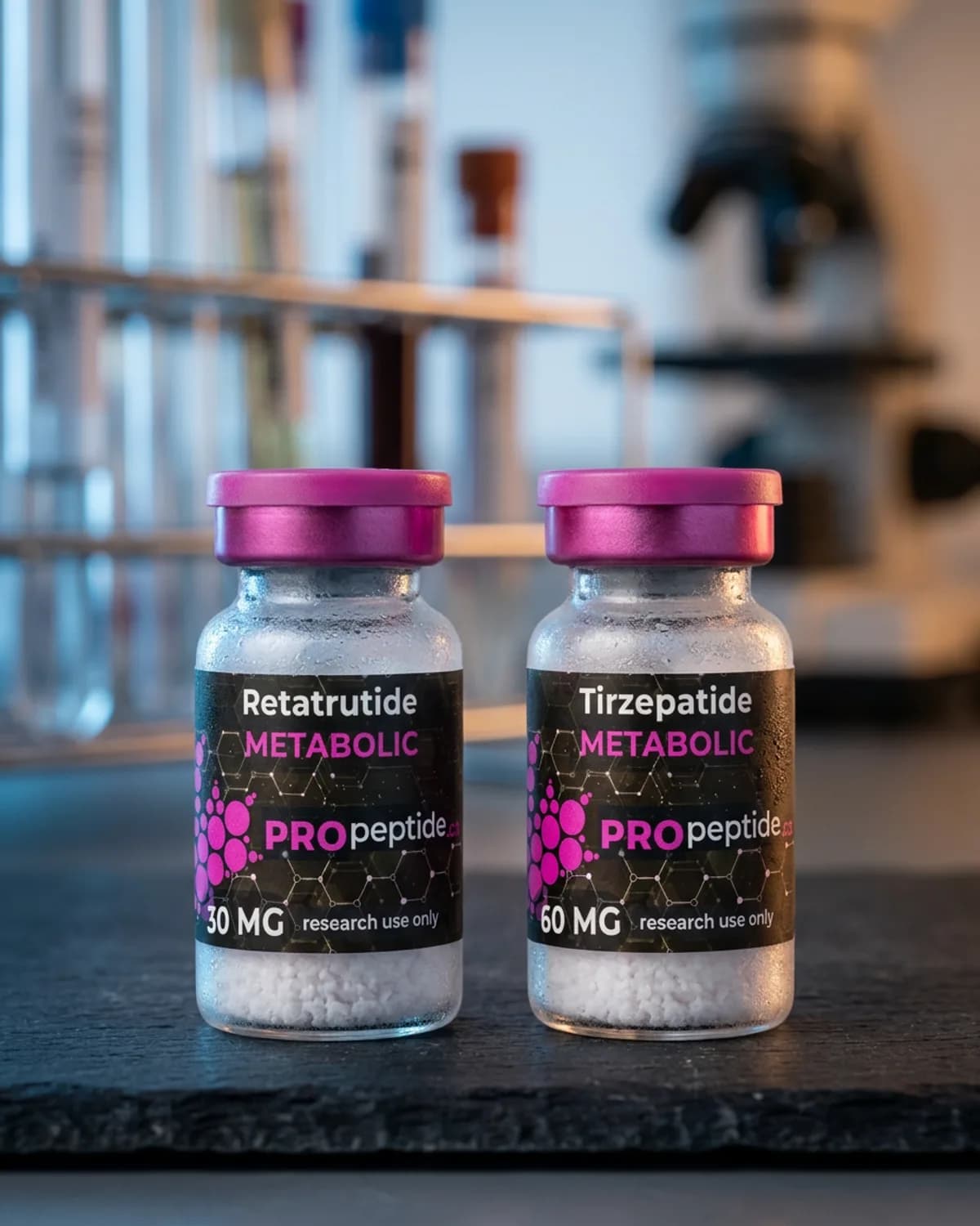 Two frosted glass vials with magenta caps and dark labels on a slate bench, blurred lab gear behind.